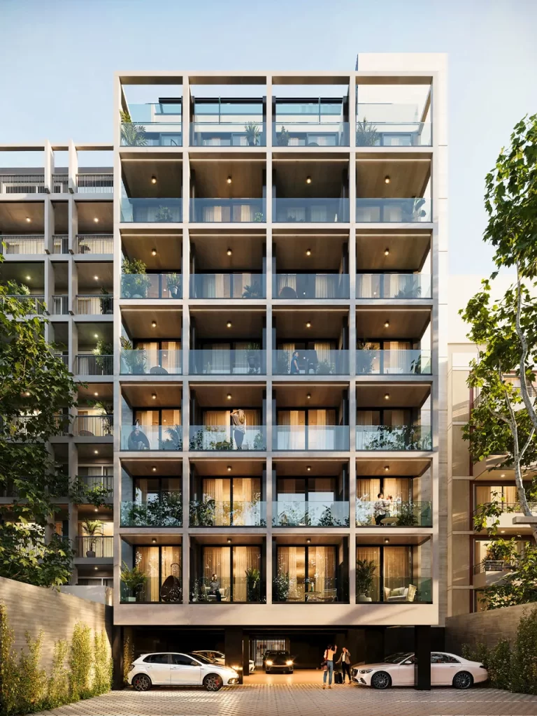 Fachada de edificio moderno con balcones y automóviles en estacionamiento.